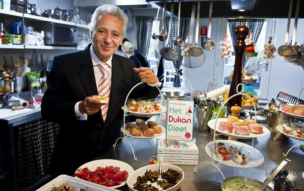 Pierre Dukan înconjurat de mâncăruri dietetice